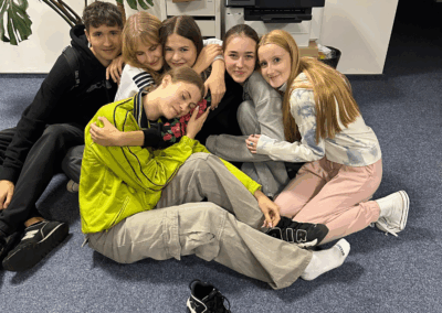 grupa sześciu młodych wolontariuszy, kt&oacute;rzy się do siebie przytulają